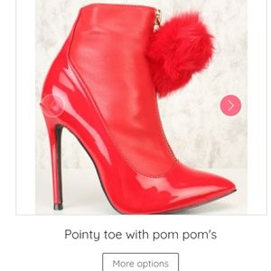 Red pointy toe boots with pom pom accent